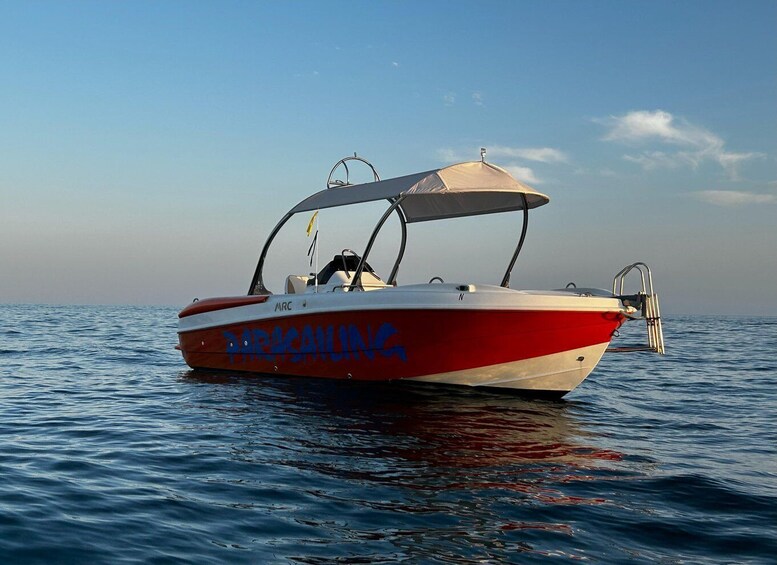 A red and white boat named 'DARKSAILING' on calm water. 2