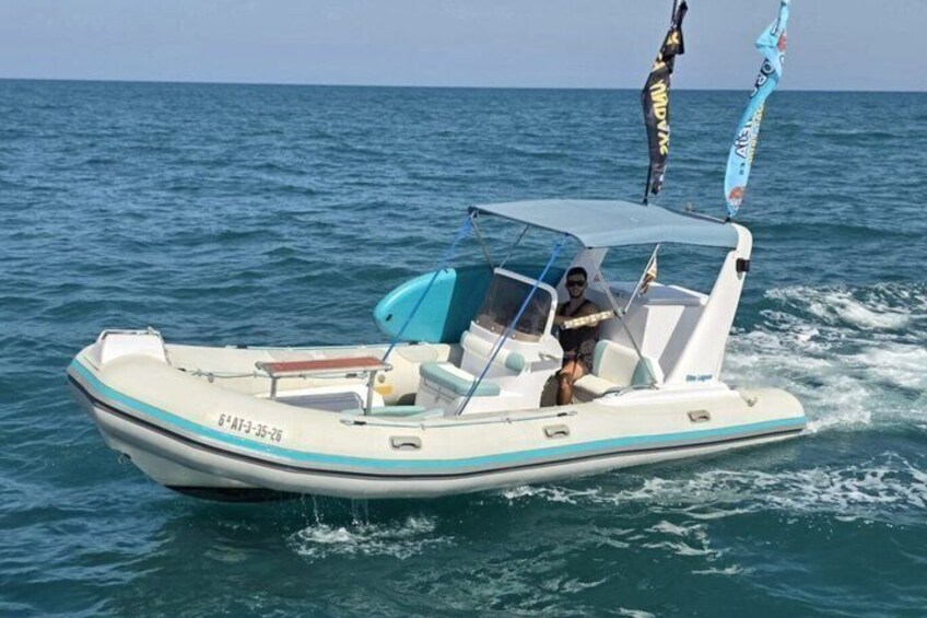 A small white motorboat with blue accents on the water. 1