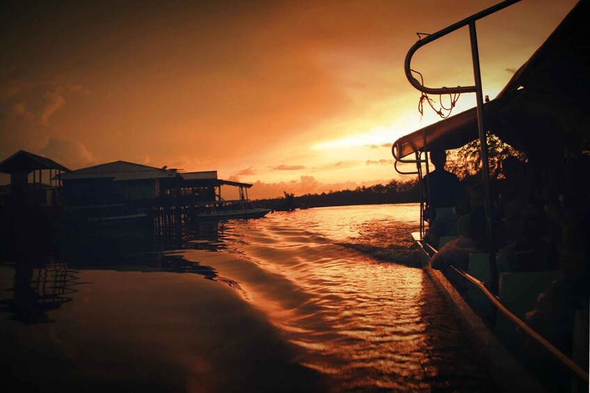 A sunset over a river with boats and buildings in the background. 5