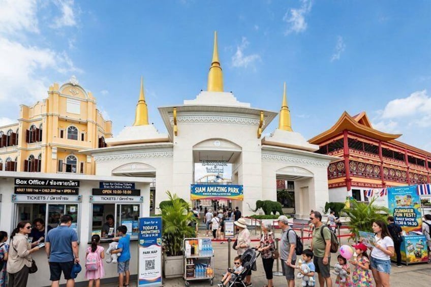 A busy entrance to a park with ticket booths and a Siam Ambling Park sign. 1