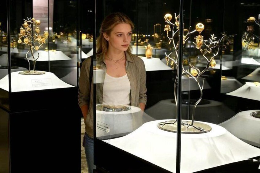 A person standing in front of a display with glass cases containing decorative items. 1