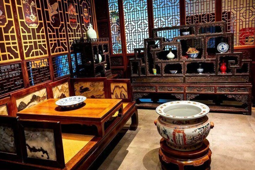 A traditional Chinese interior with wooden furniture, intricate carvings, and a decorative stove. 2
