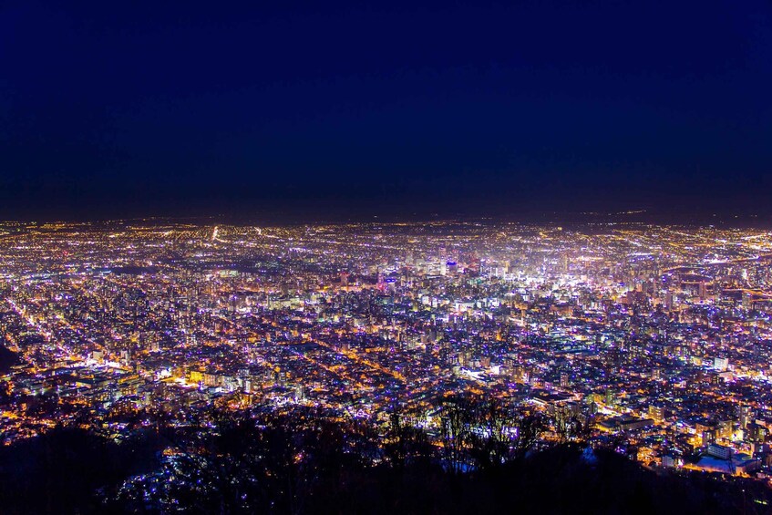 A nighttime cityscape with dense urban lighting. 1