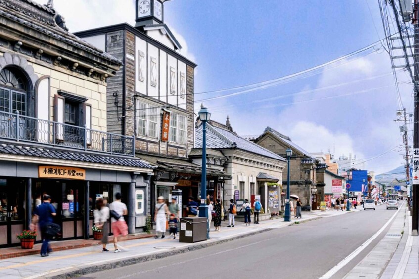A street with traditional buildings, pedestrians, and a clear sky. 2