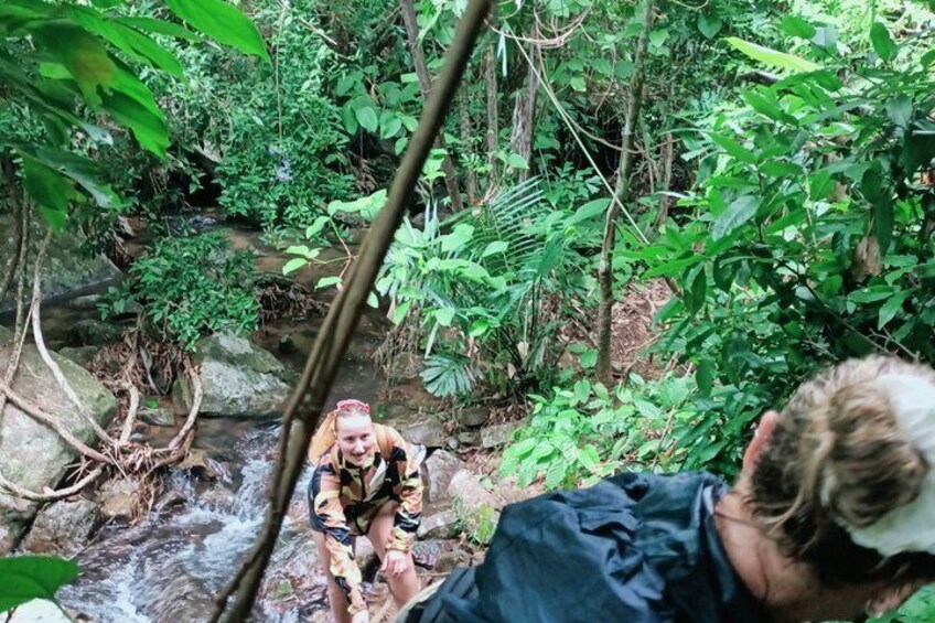 A person crossing a stream in a forested area. 2