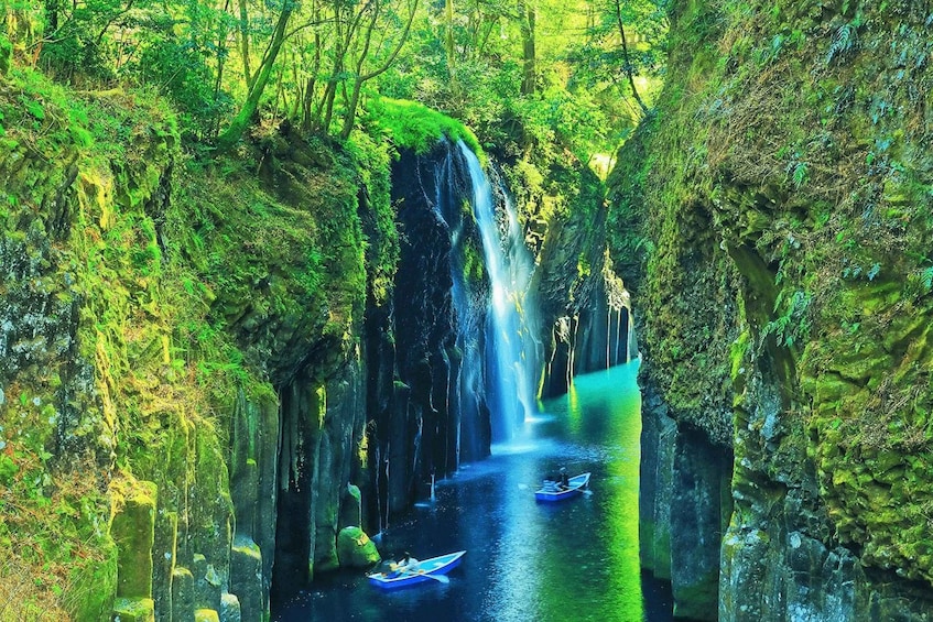 A waterfall in a forested area with moss-covered rocks and a narrow waterway. 2