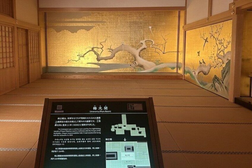A traditional Japanese room with a mural, a tatami mat floor, and a wooden screen. 5