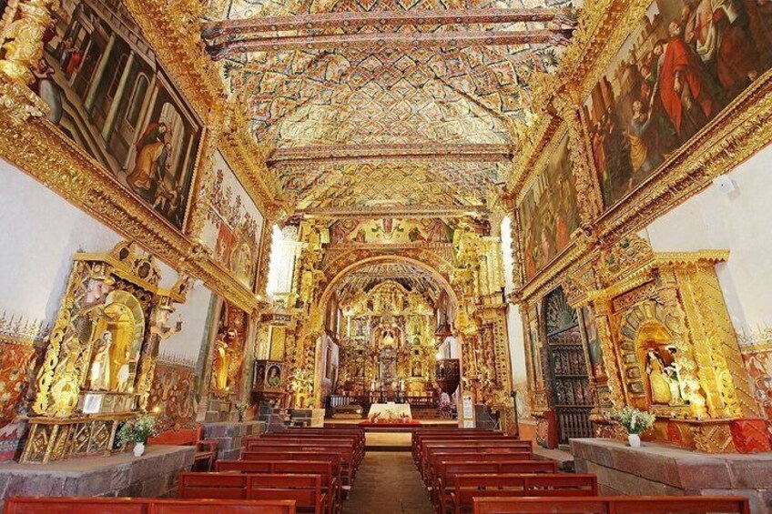 An ornate church interior with golden decorations, religious paintings, and pews. 5