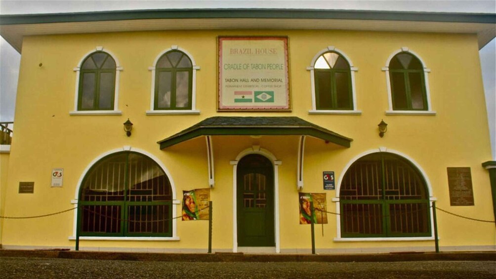 A yellow building with arched windows and a sign that reads 'Brazil House, Cradle of African People.' 5
