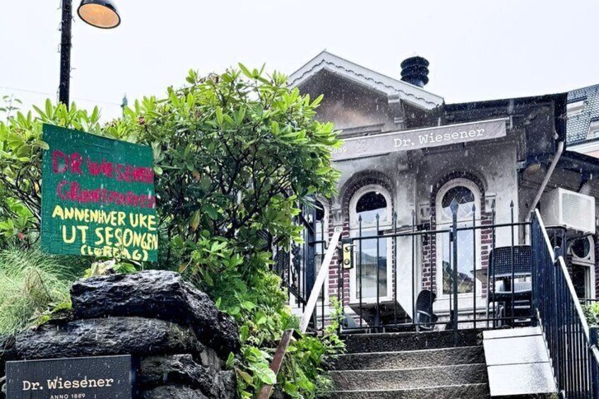 A building labeled 'Dr. Wiesener' with a sign in front and stairs leading up to it. 2