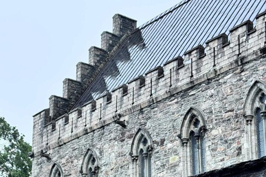 A stone building with arched windows and a metal roof. 3