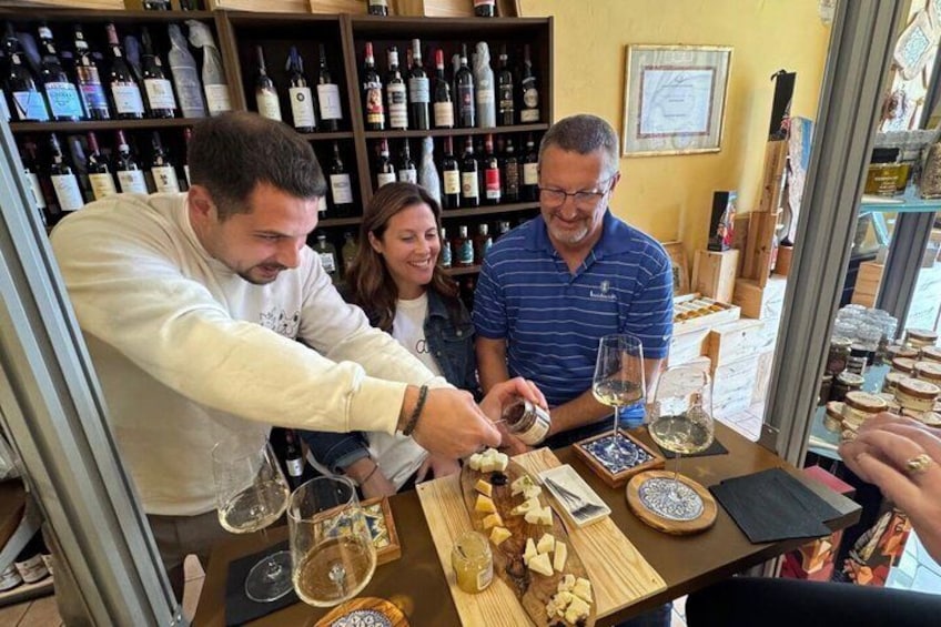 A wine tasting event with people sampling wine and cheese. 1