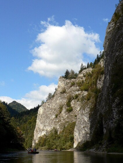 A river with a rocky cliff and a boat. 4