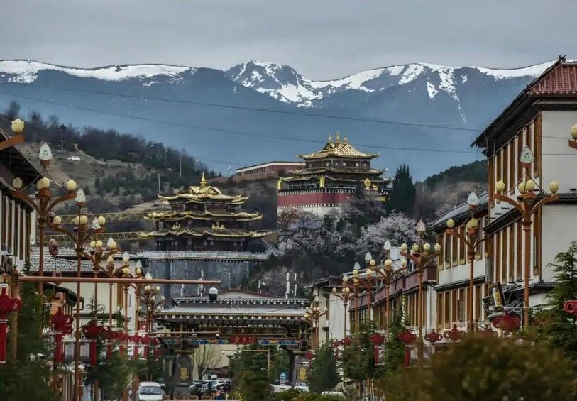 A traditional building with a golden roof, surrounded by modern buildings and a mountainous backdrop. 3