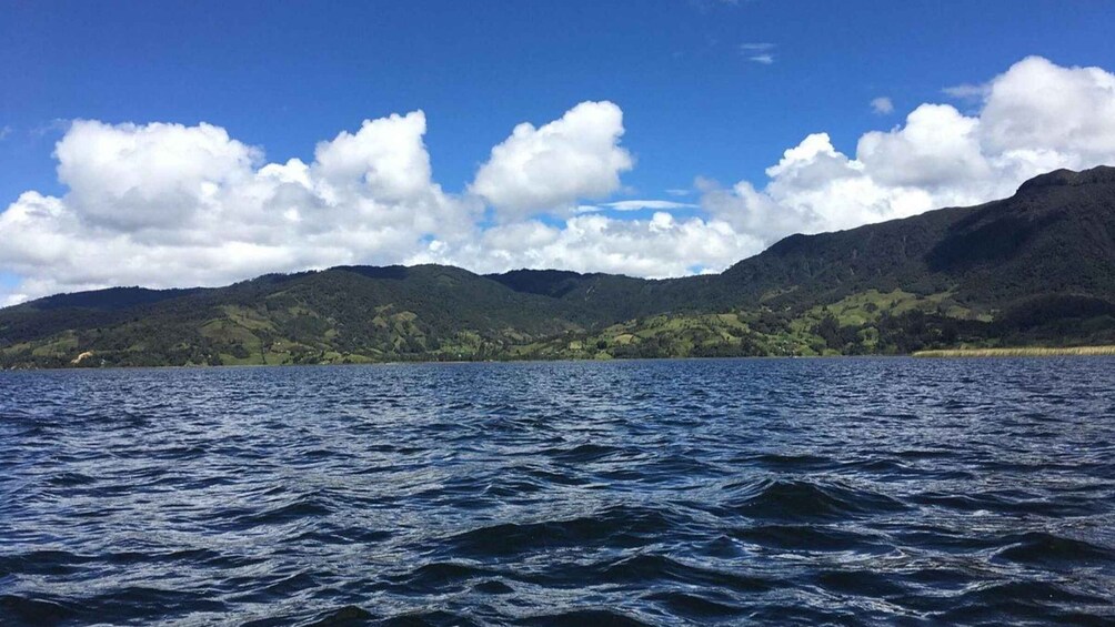 A body of water with waves, a clear sky, and mountains in the background. 4
