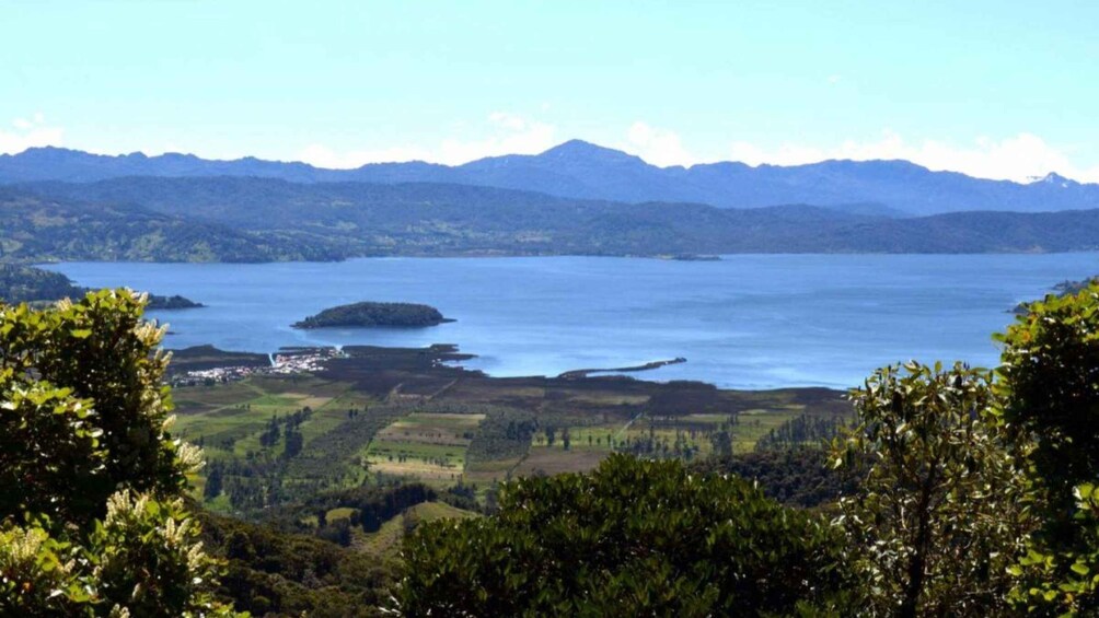 A lake surrounded by mountains and greenery. 1