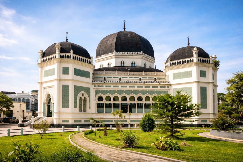 A large mosque with three domes and a central courtyard. 5