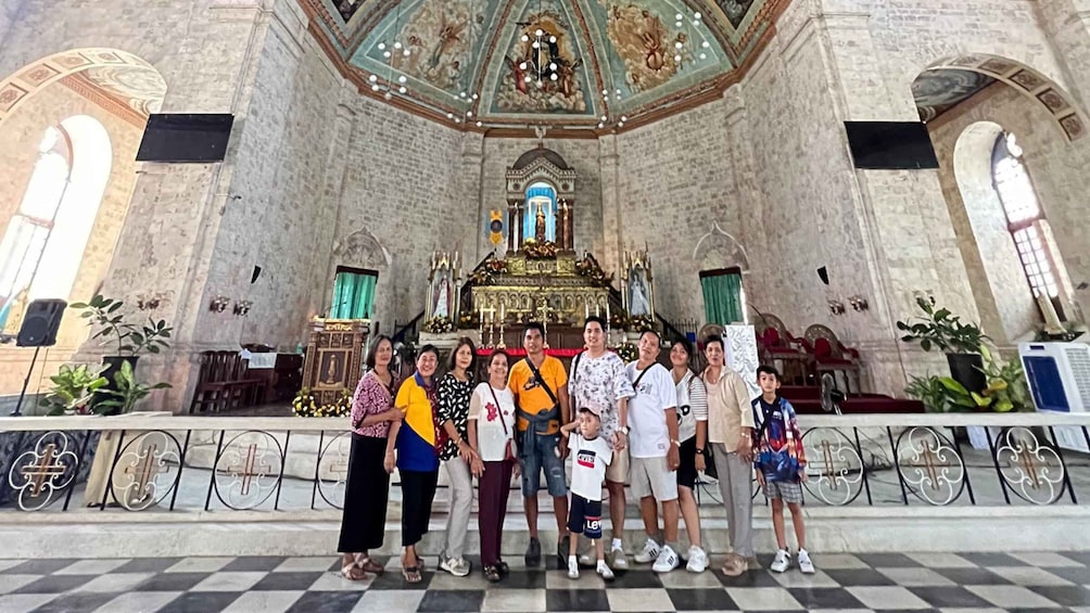 A group of people standing in front of a church with a high ceiling and ornate decorations. 5