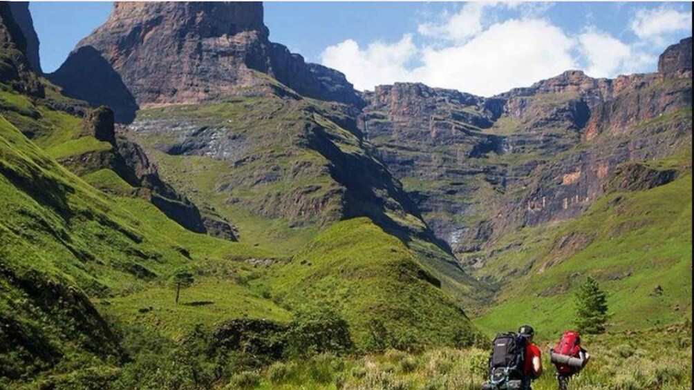 A mountainous landscape with hikers and a valley. 2