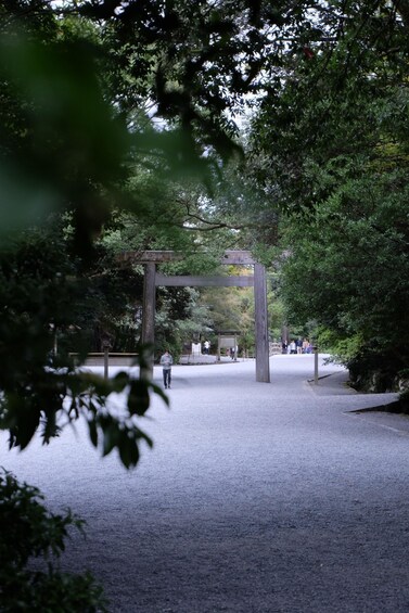 A traditional Japanese torii gate in a park with people walking around. 2