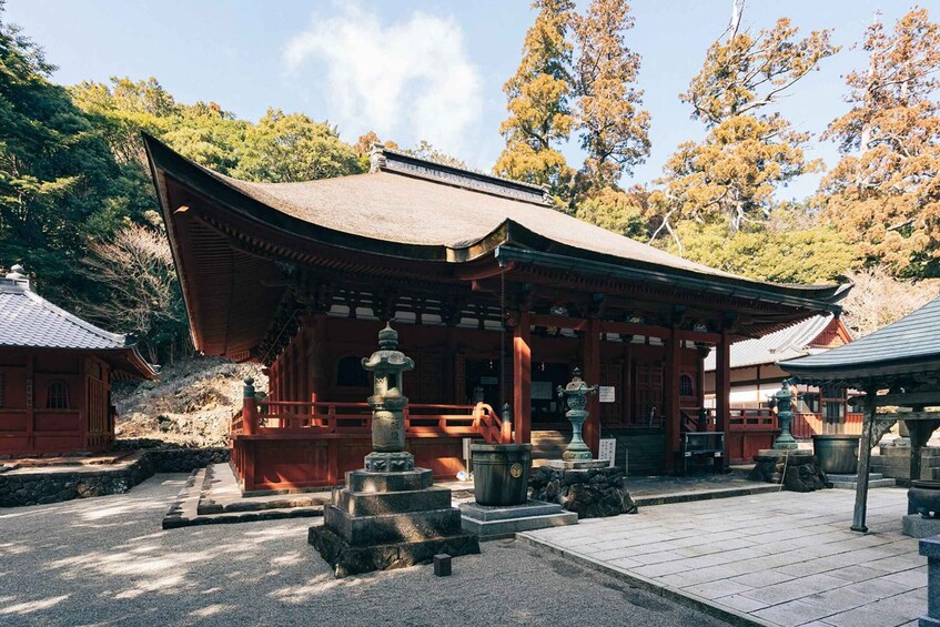 A traditional Japanese temple with a curved roof, stone lanterns, and a stone staircase leading to the entrance. 5