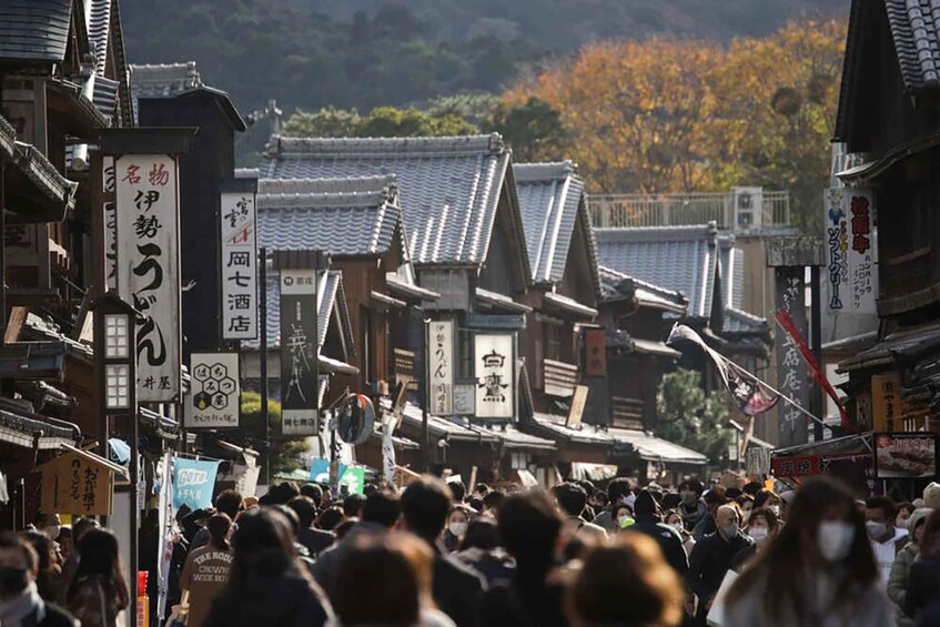 A crowded street lined with traditional Japanese buildings and signs. 1