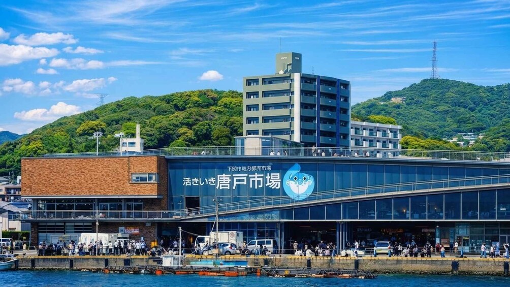 A waterfront building with a blue logo, surrounded by water and greenery. 4