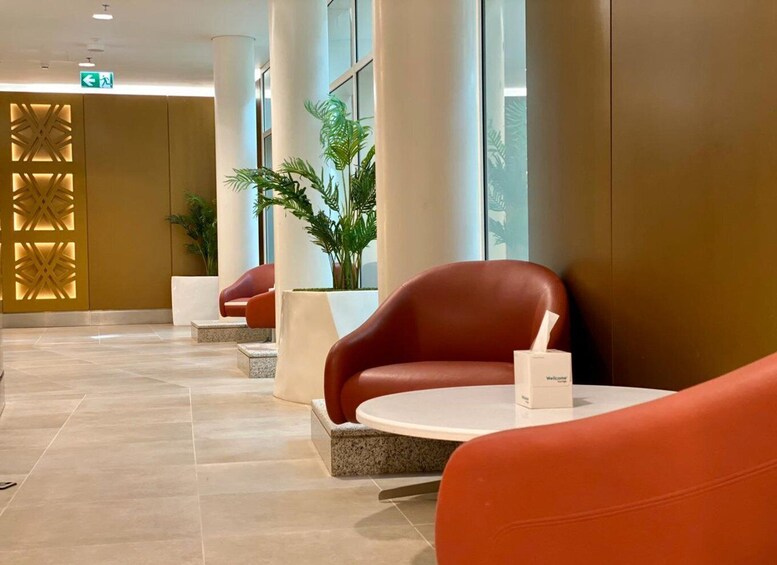 A modern lobby with red leather chairs, a Welcome mat, and a decorative wall with geometric patterns. 4