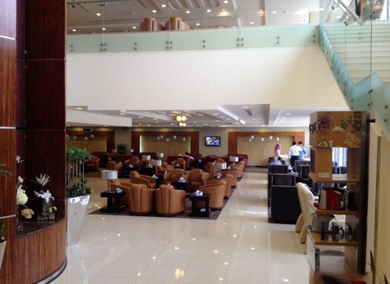 A spacious lobby with leather seating, a reception desk, and a staircase. 2
