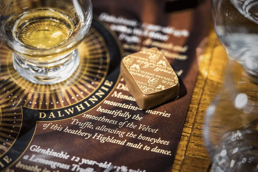 A bottle of whisky, a glass of whisky, and a menu with text. 4