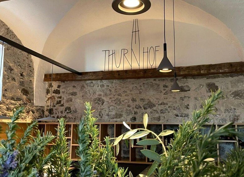 A rustic interior with exposed stone walls, wooden beams, and hanging pendant lights. 2
