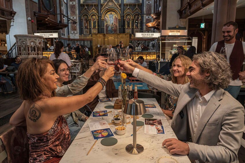 A group of people toasting with wine glasses in a bar with a historical interior. 1