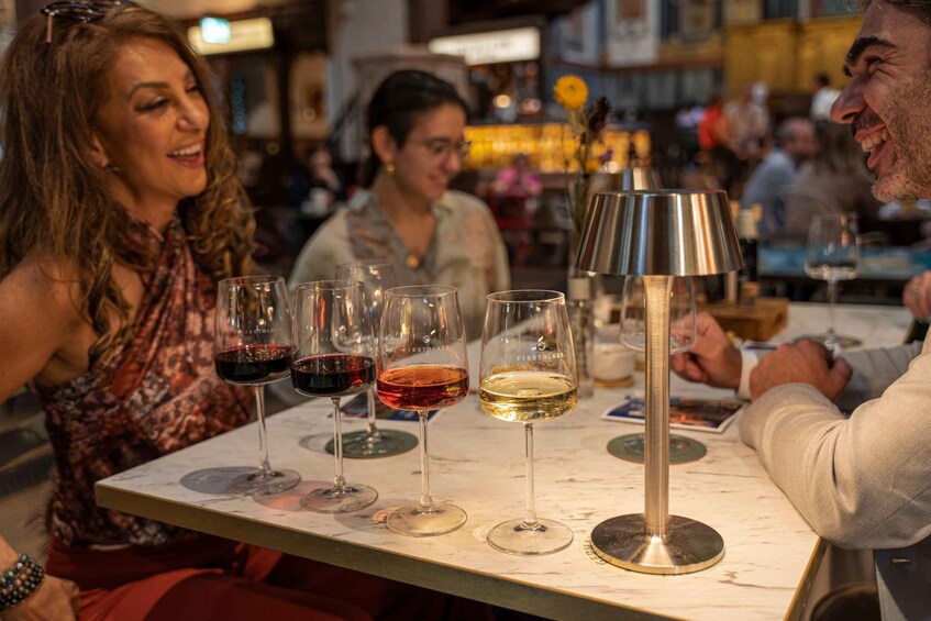 A group of people sitting at a table with wine glasses. 2