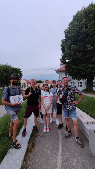 A group of people standing on a concrete path with a building and trees in the background. 4