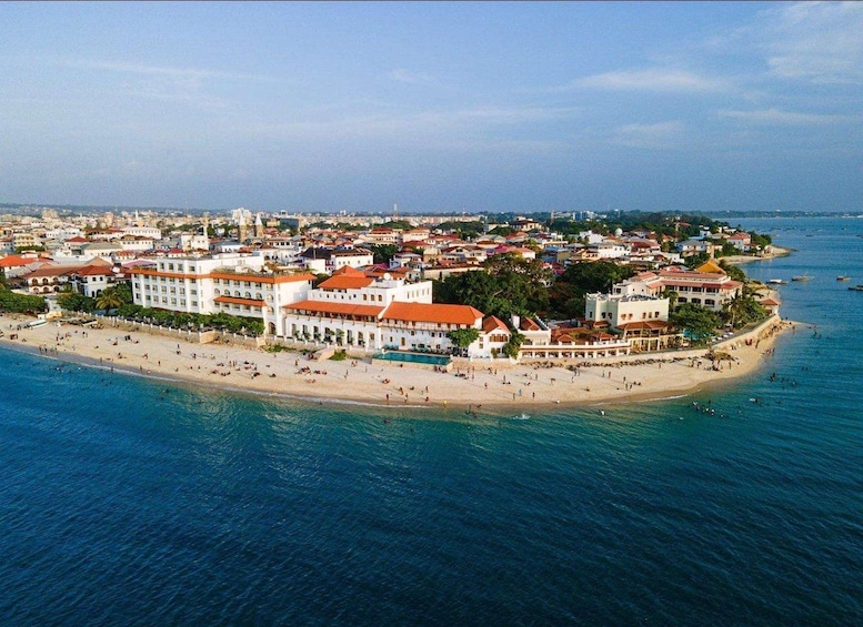 A coastal cityscape with a beach, buildings, and a clear sky. 5