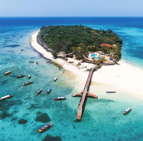 An island with a beach, a swimming pool, and a pier with boats. 3