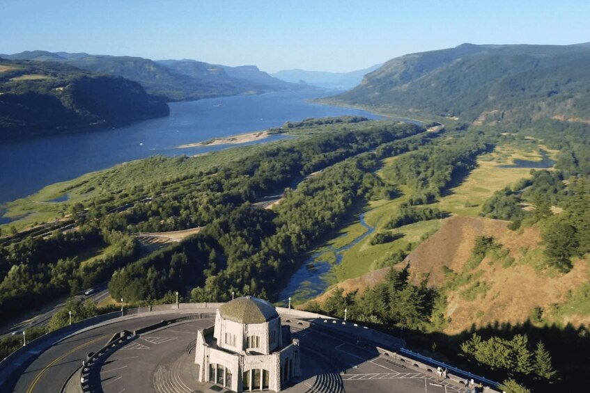 A mountainous landscape with a lake, a road, and a building with a dome. 4