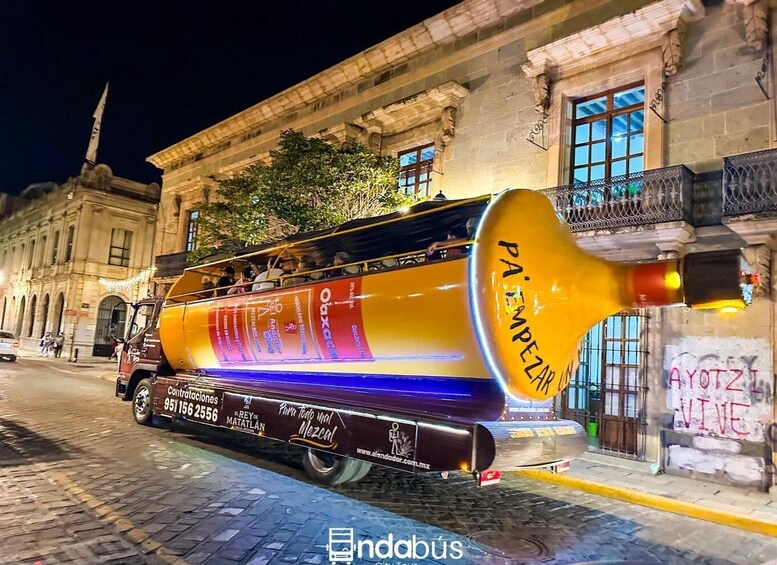 A colorful bus with 'PA EMPEZAR' written on the back, parked on a cobblestone street at night. 1