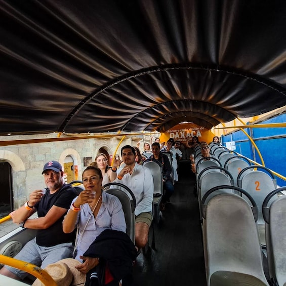 A bus interior with passengers seated and a driver at the front. 4