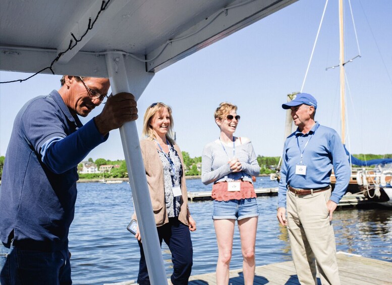 A group of people on a boat with a dock and water in the background. 4