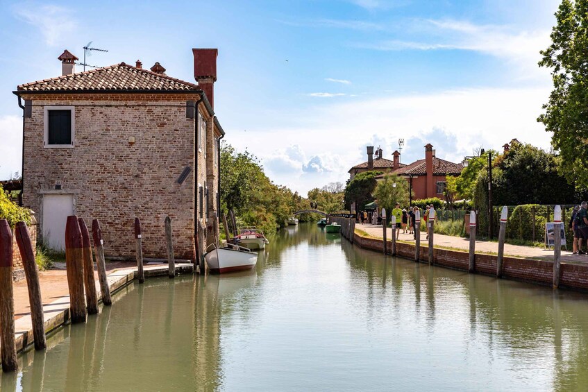 A canal with boats, a brick building, and a bridge. 2