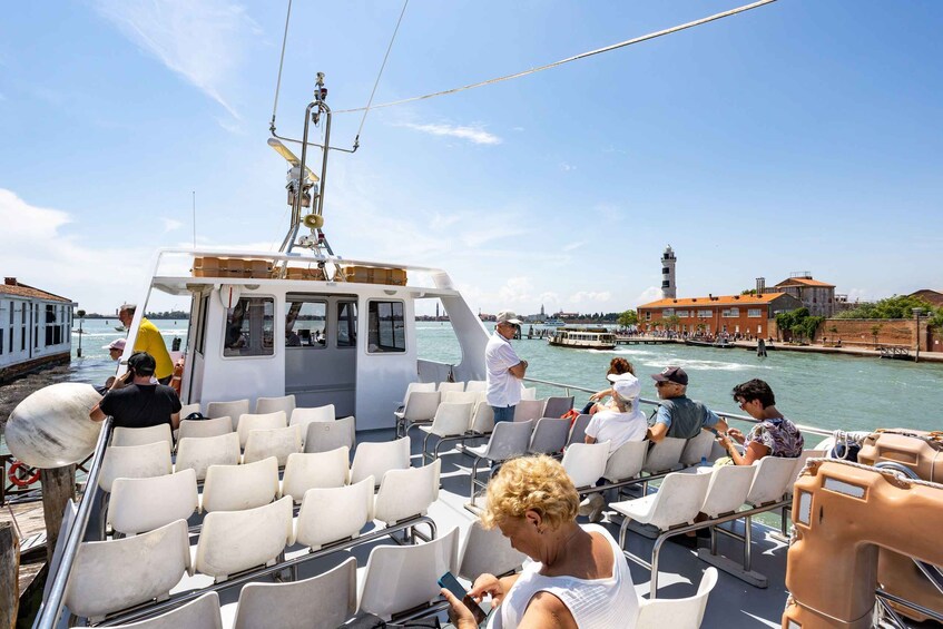 A boat with passengers, a lighthouse, and historic buildings in the background. 5
