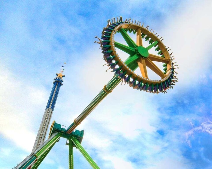A roller coaster with a large circular loop against a sky with clouds. 5
