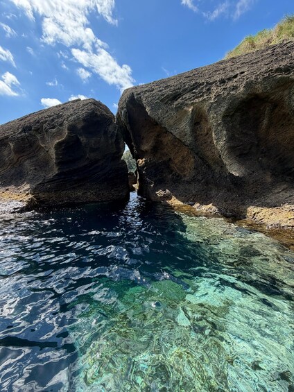 A clear blue sky, rocky cliffs, and a narrow water passage. 2