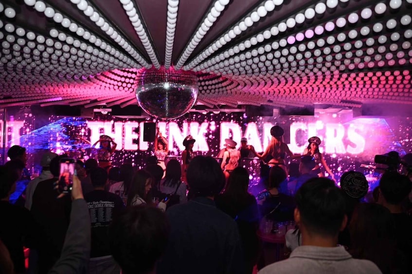 A nightclub with a disco ball and a stage with performers. 3