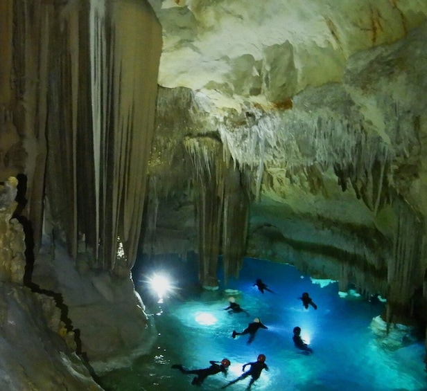 A group of divers in a cave with stalactites and stalagmites. 3