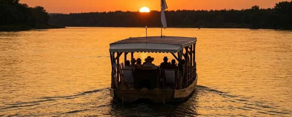 A boat with passengers at sunset on a calm lake. 3