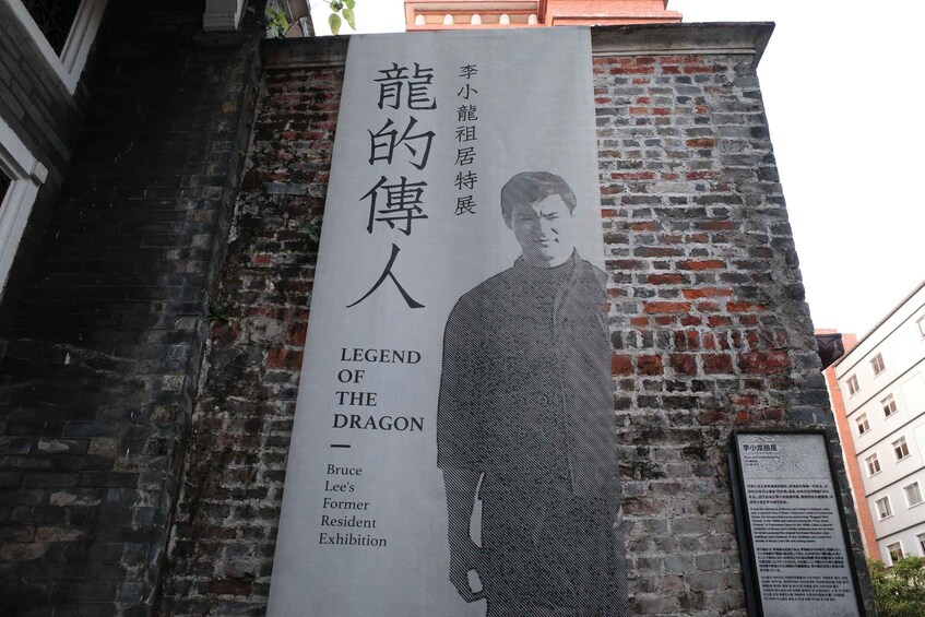 A poster with a person's silhouette and text in a foreign language, mounted on a brick wall. 2