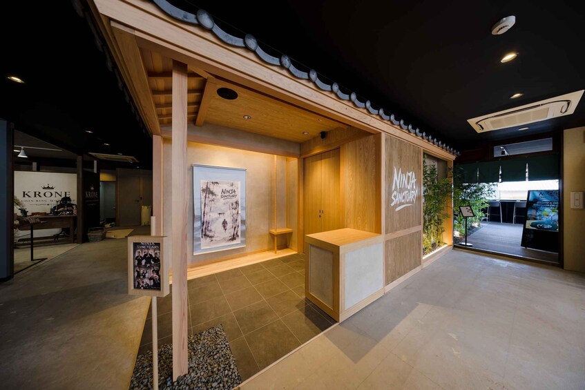 A wooden interior with a poster of a ninja sanctuary, a reception desk, and a sign for 'KRONE Coin Ring Workshop'. 3