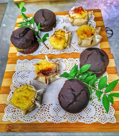 A wooden board with pastries and green leaves. 4